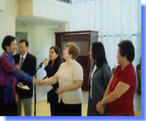 Mr. Dela Cruz shakes the hand of Mrs. Begonia Ortigas during Awarding Ceremonia at Malacanang 