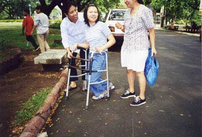 A teenage girl with cerebral paisy walks with a walker provide by the center. 